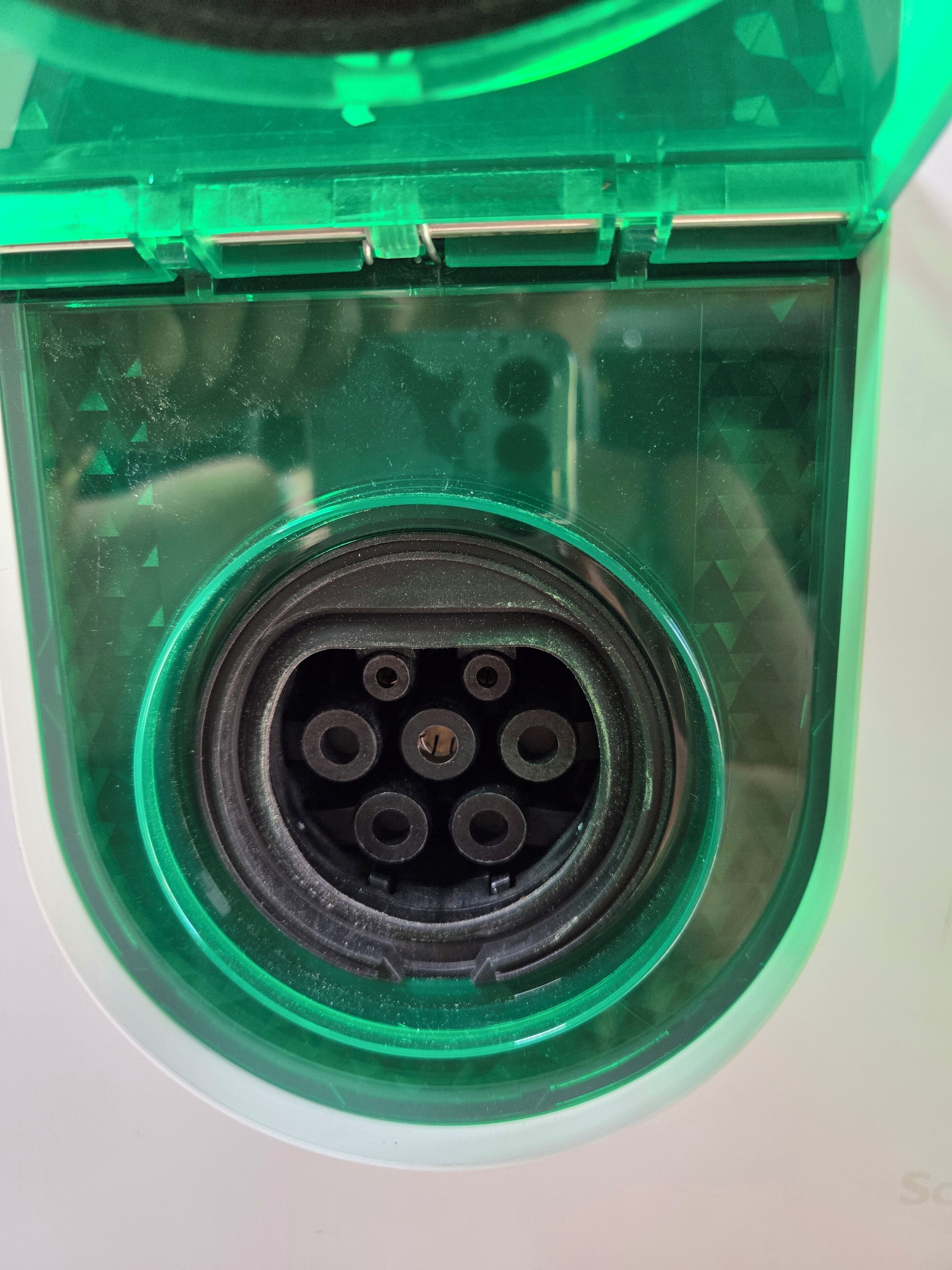 Primer plano de un conector eléctrico de plástico verde con seis puertos.