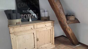 Un buffet en bois rustique, agrémenté de paniers tressés et d’une enseigne placée au-dessus.