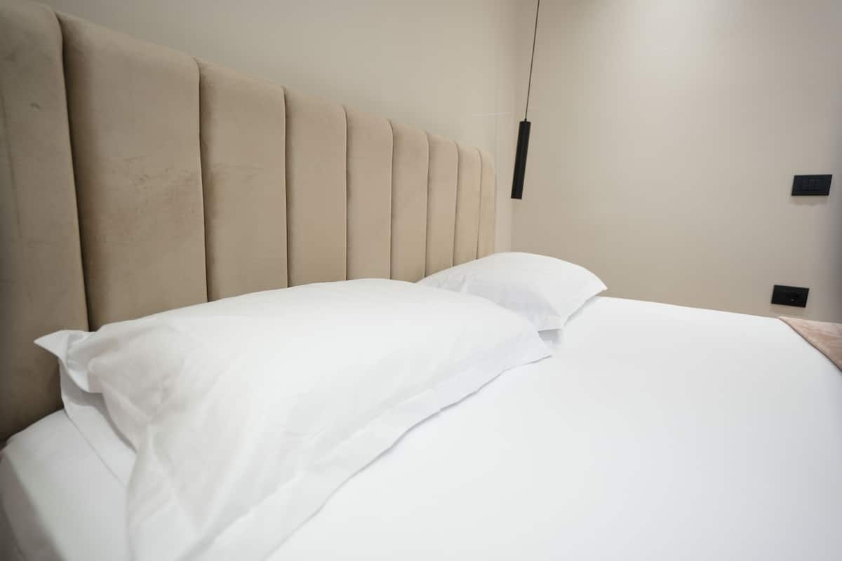 A bed with a headboard and two pillows.