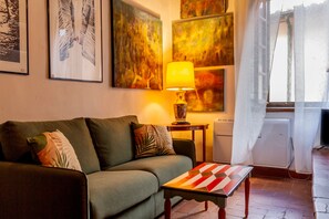 Un salon avec un canapé, une table et des œuvres d’art accrochées au mur.