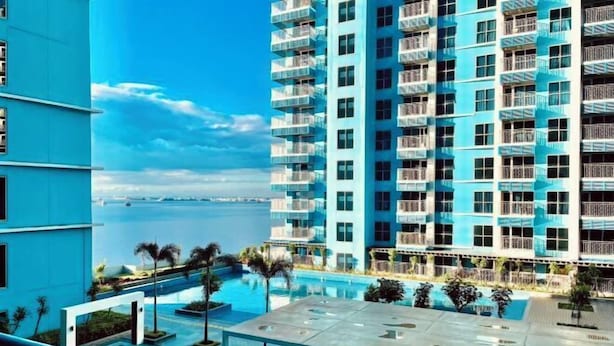 Un hôtel de grande hauteur doté d’une piscine, de nombreux balcons et offrant une vue sur la mer.