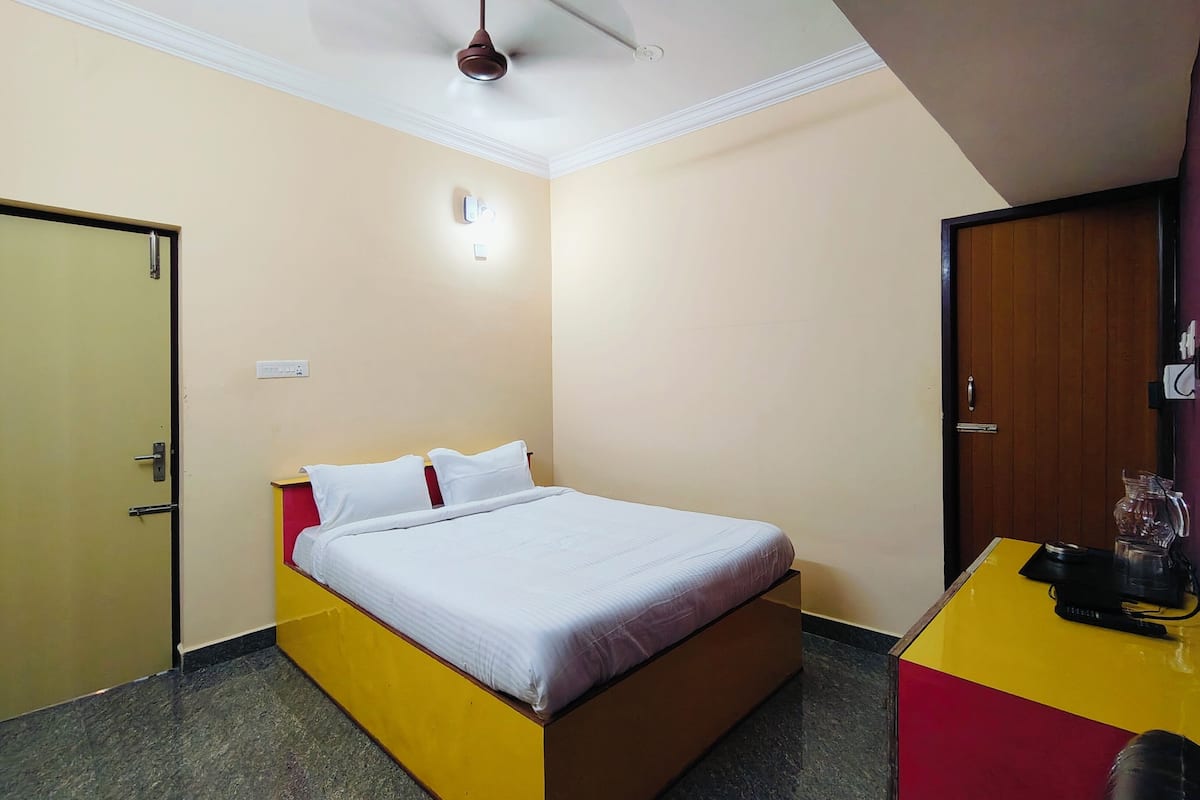A hotel room with a bed, a desk, and a wardrobe.