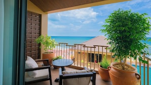 A balcony with a view of the sea, a table, chairs, and potted plants. - Pandora Sand Hill Mui Ne Resort (Mui Ne)