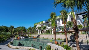 A resort with a swimming pool, palm trees, and a white building with balconies. - Pandora Sand Hill Mui Ne Resort (Mui Ne)