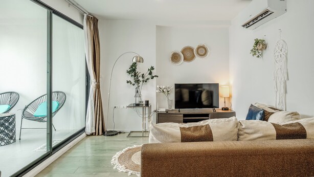 A modern living room with a sofa, TV, and decorative items.