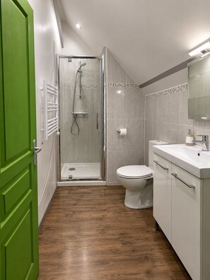 A modern bathroom with a shower, toilet, and vanity. - Bed and Breakfast on the Loire Valley Bike Route (Les Ponts-de-Cé)