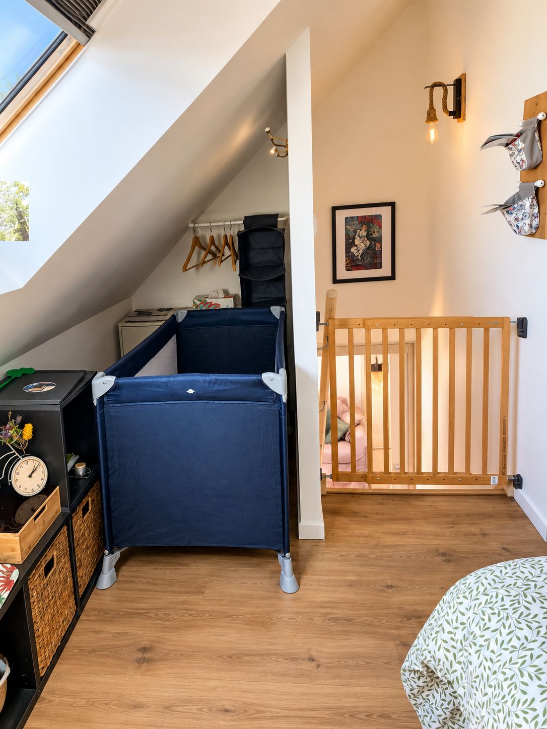Une pièce avec un lit en mezzanine, un berceau, un plancher en bois, un radiateur fixé au mur et une fenêtre avec vue.