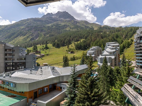 A modern hotel with a flat roof and a view of a mountainous landscape.