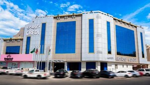 Un moderno edificio de hotel con amplios ventanales y un llamativo letrero con la palabra 'CREDIT'.
