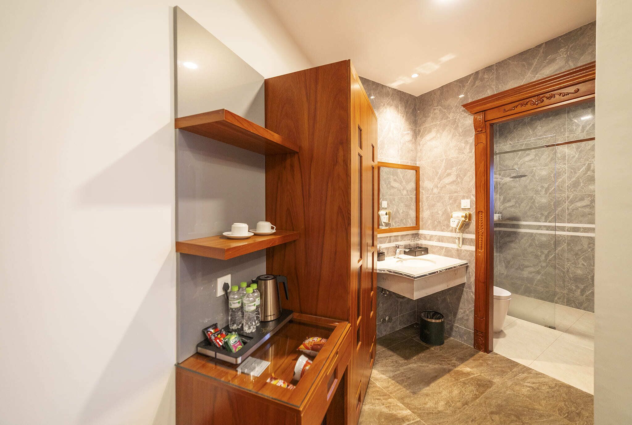 Une salle de bain moderne avec un meuble-lavabo en bois, un meuble vitré et un espace de douche en marbre.