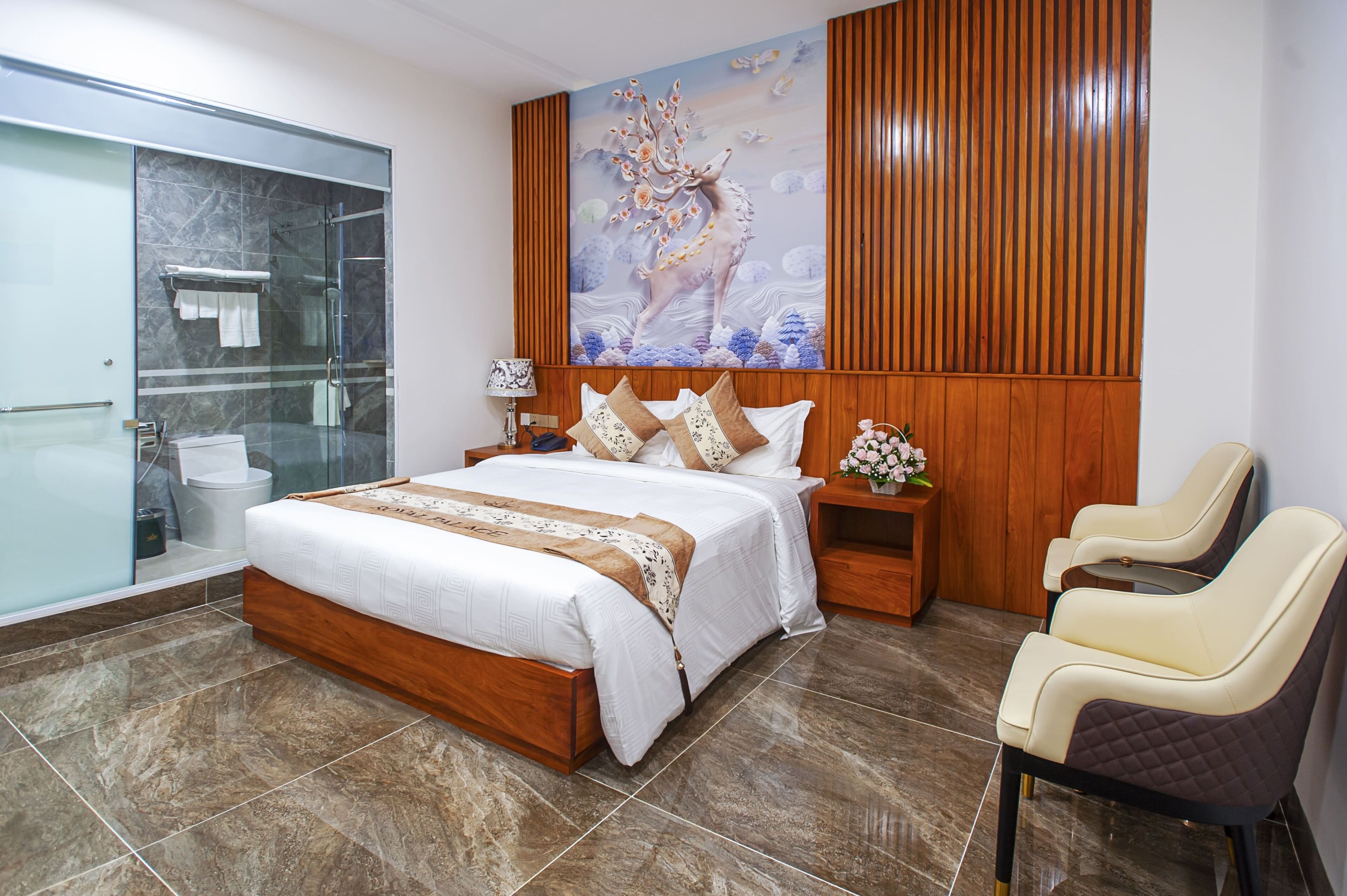 A modern bedroom with a large bed, a glass shower enclosure, a wooden headboard, and a decorative wall mural.