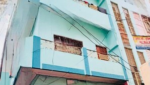 A multi-story building with a light blue facade, multiple balconies, and a visible sign for a guest house. - Maa Vaishnavi guest house (Varanasi)