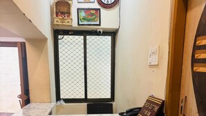 A reception desk with a marble top, a clock, and framed pictures on the wall. - Maa Vaishnavi guest house (Varanasi)