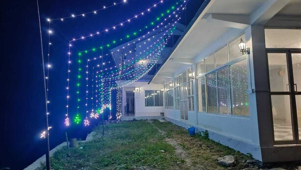 A building with a covered outdoor area decorated with string lights. - Vinayaka Inn Sittong (Kurseong)