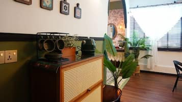 A room with a wooden cabinet, a mirror, and a potted plant.