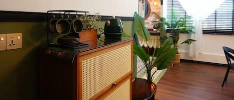 Une pièce avec un meuble en bois, un miroir et une plante en pot.