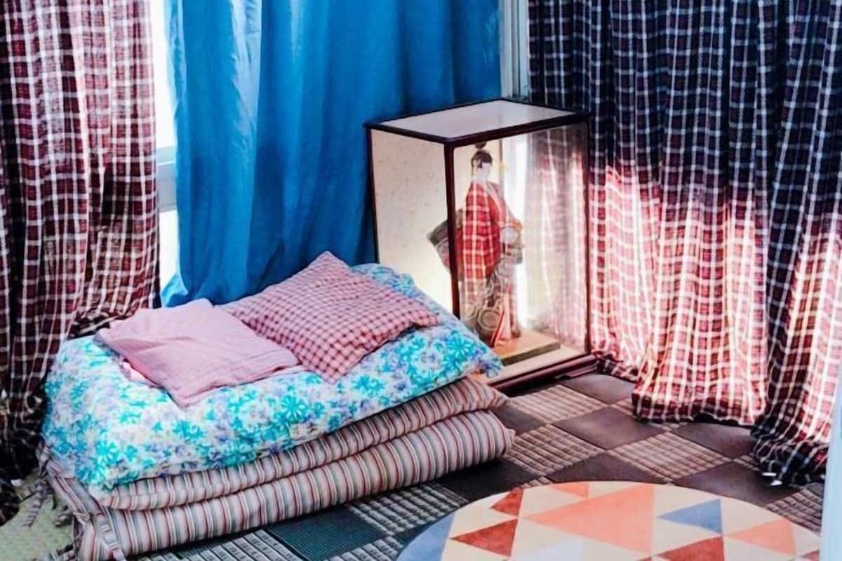 Une pièce avec un lit, une vitrine et des rideaux.