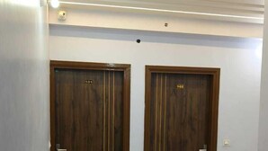Een hal met twee houten deuren, waarop 101 en 102 staat, een betegelde vloer en inbouwspots.
