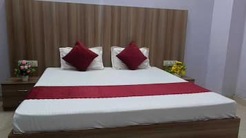 Un dormitorio moderno con una cama grande, cabecera de madera y una manta roja.