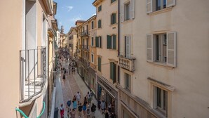 Un carrer estret amb edificis a banda i banda, balcons i una passera per vianants.