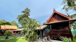 A traditional wooden building with a sloped roof, surrounded by greenery and other similar structures. - Greenplace-Samed Seahorse (Rayong)