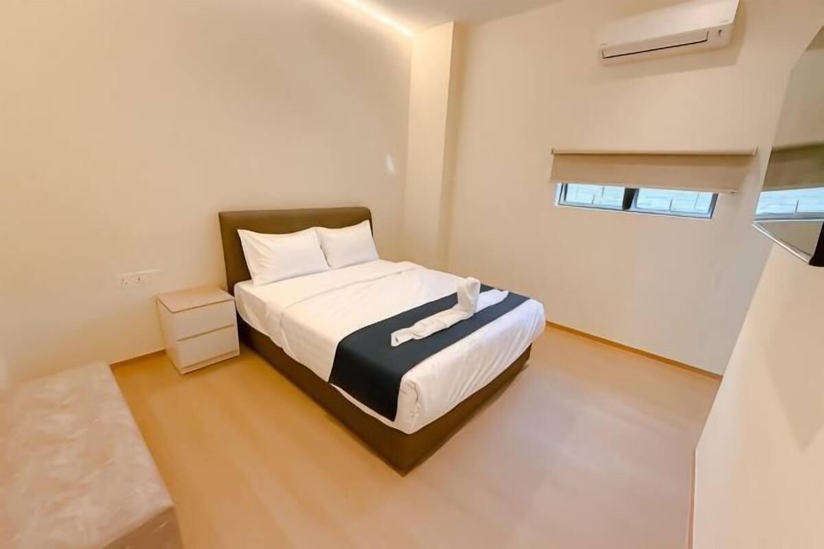 Une chambre à coucher avec un lit, une table de chevet et une fenêtre.
