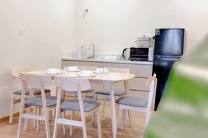 Una cocina compacta equipada con refrigerador, microondas y cafetera.