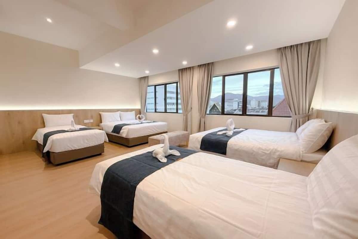 Une chambre d’hôtel avec trois lits, une vue sur la ville et un design moderne.