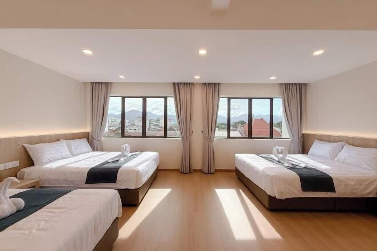 Une chambre d’hôtel avec deux lits, une vue sur la ville et un plancher en bois.