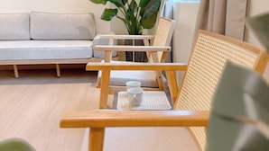 A room with a sofa, two wooden chairs, a small table with two cups, and a plant. - Resandau Stay Ipoh - Nearby Ipoh Town - Private Car Park and Lift - Whole Unit & Coliving (Ipoh)