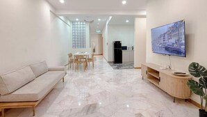 A modern hotel lobby with a marble floor, a sofa, a dining area, a TV mounted on the wall, and a potted plant. - Resandau Stay Ipoh - Nearby Ipoh Town - Private Car Park and Lift - Whole Unit & Coliving (Ipoh)