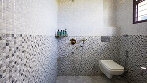 Uma casa de banho com chuveiro, sanita e um armário com artigos de higiene pessoal.