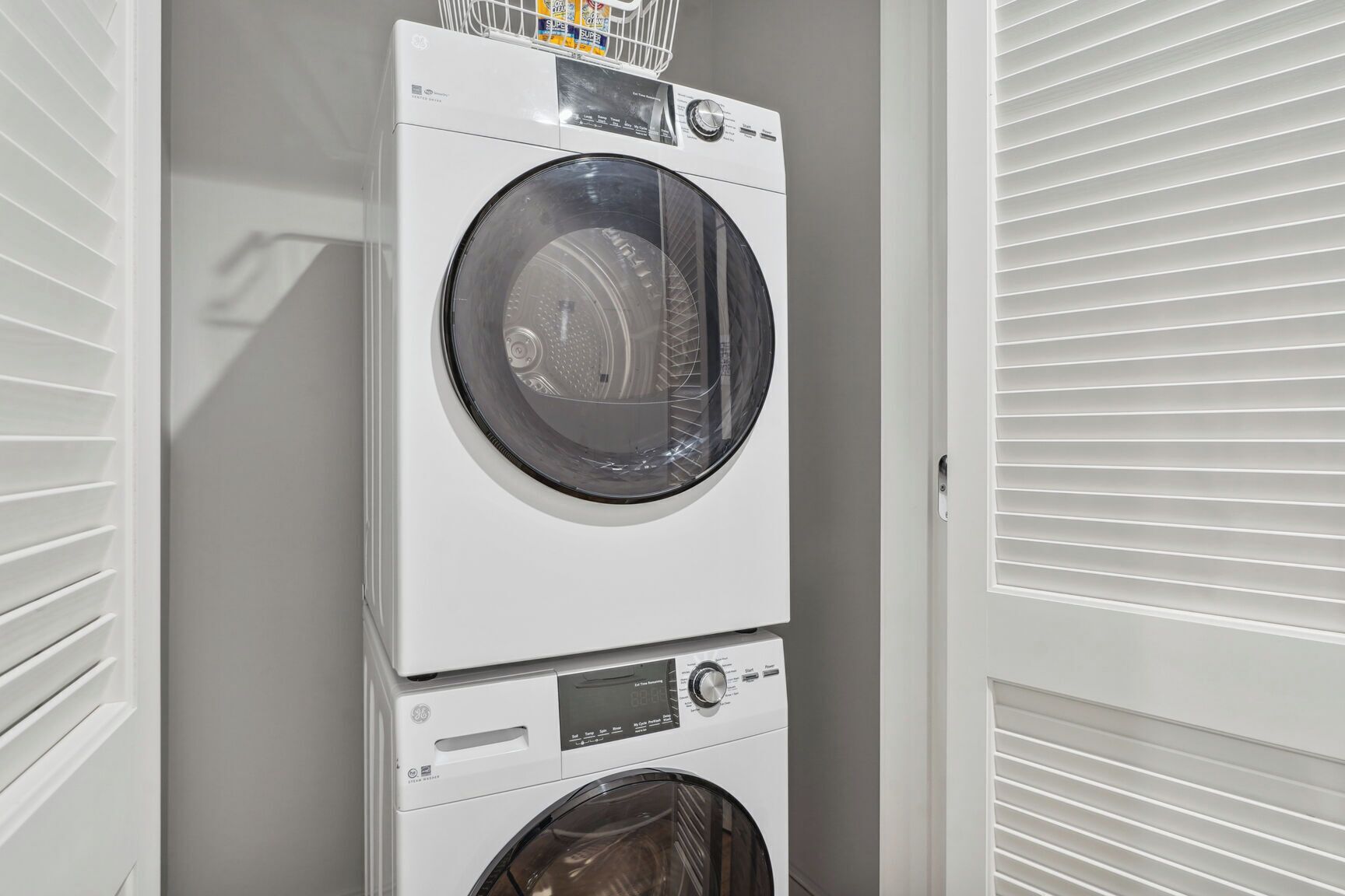 A stacked washer and dryer unit in a laundry room.