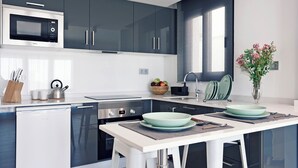 Une cuisine moderne avec des meubles de couleur sombre, un four à micro-ondes, un lave-vaisselle et un évier.
