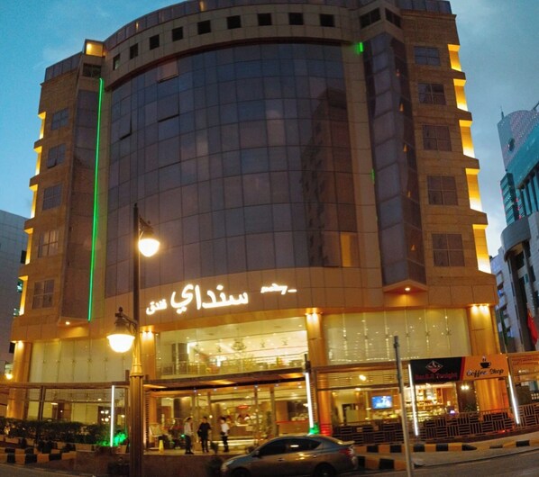 A modern building with a glass facade and illuminated signage.