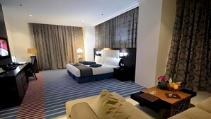 Ein Hotelzimmer mit einem Bett, einem Schreibtisch, einem Sofa und einem Couchtisch.