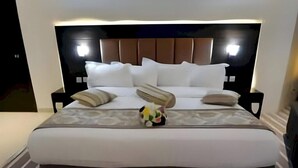 Ein großes Bett mit Kopfteil, mehreren Kissen und einer Dekoration.
