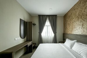 A hotel room with a bed, a TV, a desk, and a window with curtains. - E-Hotel @ Kulim (Kulim)