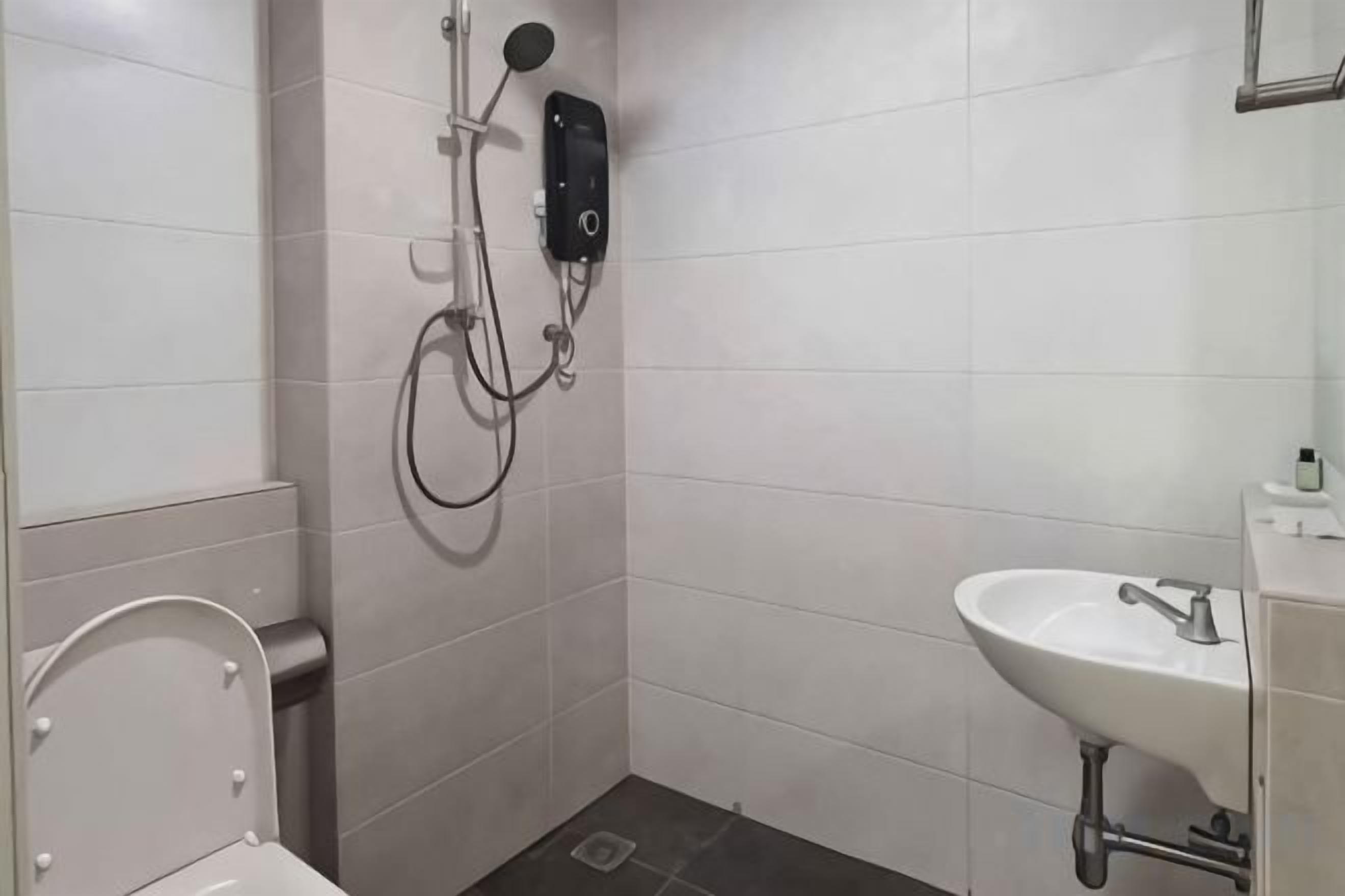 A bathroom with a toilet, a sink, and a shower with a handheld showerhead.