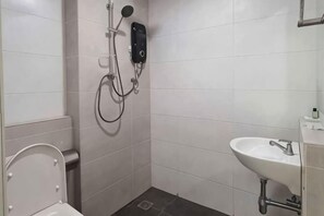 A bathroom with a toilet, a sink, and a shower with a handheld showerhead. - E-Hotel @ Kulim (Kulim)