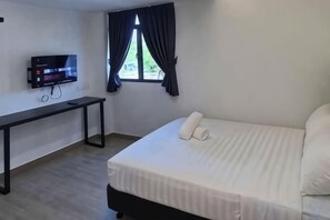 A hotel room with a bed, a desk, a television, and a window with curtains. - E-Hotel @ Kulim (Kulim)