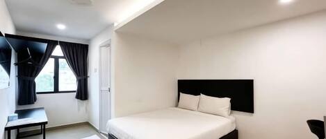 Un dormitorio con cama, escritorio y silla.