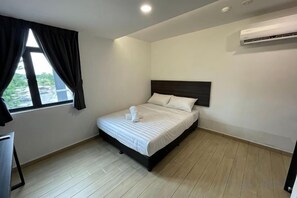 A bedroom with a bed, a window with curtains, an air conditioning unit, and a desk. - E-Hotel @ Kulim (Kulim)