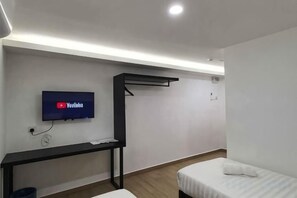 A room with a bed, a desk, a TV mounted on the wall, and a hanging rack. - E-Hotel @ Kulim (Kulim)