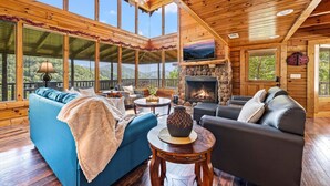 Un salón amplio con un sofá grande azul, una chimenea y una pared de piedra.