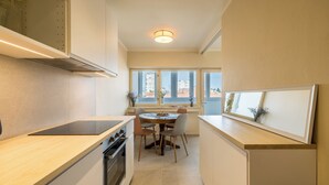 Une cuisine moderne avec un coin repas, de grandes fenêtres et une vue sur la ville.
