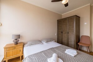 Une chambre à coucher avec un lit, une table de chevet avec une lampe, une armoire et une chaise.