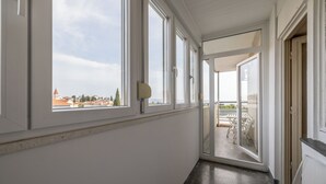 Un couloir doté de grandes fenêtres donnant sur un bâtiment au toit rouge.