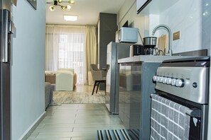 Cocina compacta con refrigerador, microondas y estufa.