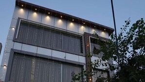 A modern building with a glass entrance, decorated with string lights and floral arrangements. - Shubh Laxmi Residence (Ajmer)